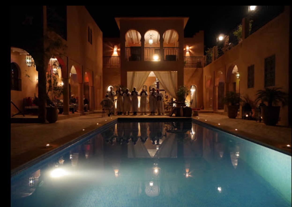 Riad présenté par ImmoConst : arcades et piscine à la nuit tombée